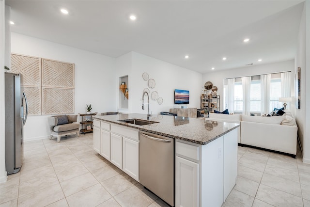 17918 Rillette Rd, Conroe, TX 77302 - kitchen featuring stainless steel appliances, open floor plan, stone countertops, white cabinets, and light tile patterned floors