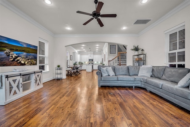 8720 Kempwood Dr, Houston, TX 77080 - living area with arched walkways, a ceiling fan, ornamental molding, stairway, and wood finished floors