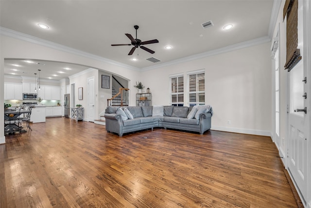 8720 Kempwood Dr, Houston, TX 77080 - living area featuring stairway, a ceiling fan, arched walkways, dark wood finished floors, and crown molding