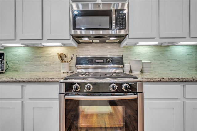 8720 Kempwood Dr, Houston, TX 77080 - kitchen with appliances with stainless steel finishes, tasteful backsplash, white cabinetry, and light stone countertops