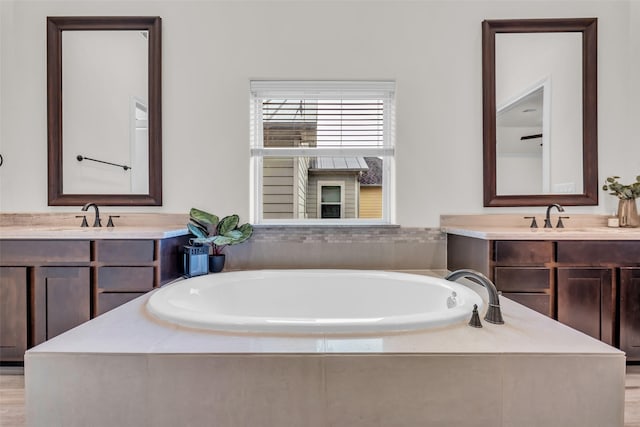 8720 Kempwood Dr, Houston, TX 77080 - bathroom with a garden tub, vanity, and wood finished floors