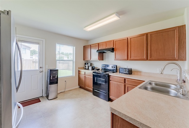 9902 Waldens Pond Ct, Houston, TX 77044 - kitchen with black range with electric stovetop, fridge, under cabinet range hood, and light countertops