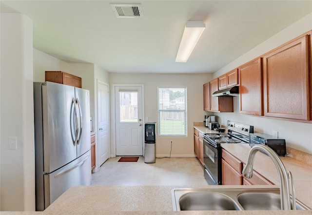 9902 Waldens Pond Ct, Houston, TX 77044 - kitchen featuring freestanding refrigerator, black electric range oven, under cabinet range hood, and light countertops