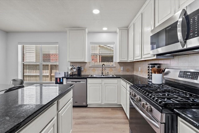 1054 Inverness Cv, Dickinson, TX 77539 - kitchen featuring stainless steel appliances, healthy amount of natural light, white cabinetry, light wood-type flooring, and recessed lighting