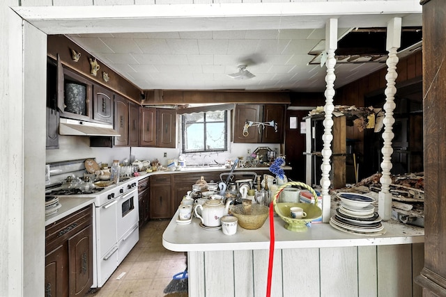 6907 Isla Rd, Brookside, TX 77581 - kitchen with range with two ovens, under cabinet range hood, light countertops, and dark brown cabinets