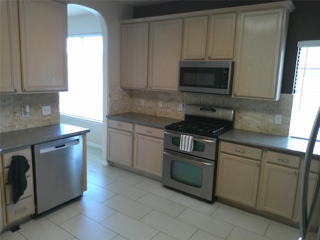 3307 Norma Ln, Pearland, TX 77584 - kitchen with appliances with stainless steel finishes, plenty of natural light, decorative backsplash, and arched walkways