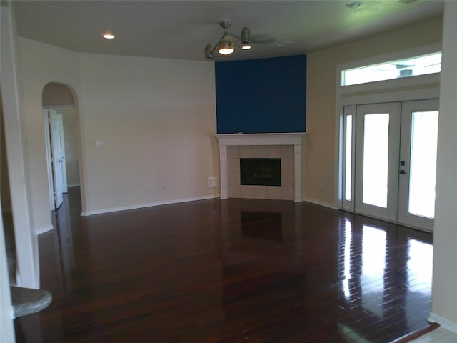 3307 Norma Ln, Pearland, TX 77584 - unfurnished living room featuring wood finished floors, arched walkways, a fireplace, recessed lighting, and french doors