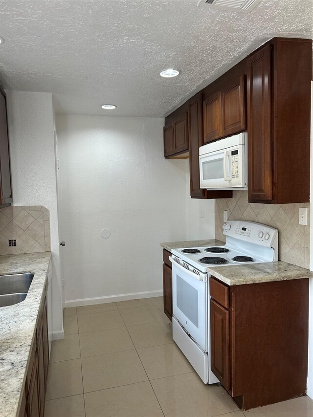 727 Doncrest St, Channelview, TX 77530 - kitchen featuring white appliances, decorative backsplash, recessed lighting, light tile patterned flooring, and a textured ceiling