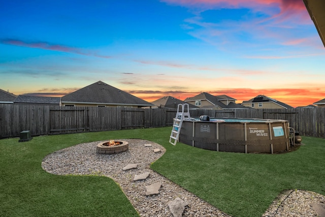 8315 Egret Bay Cir, Baytown, TX 77523 - yard at dusk featuring a fire pit and a fenced backyard