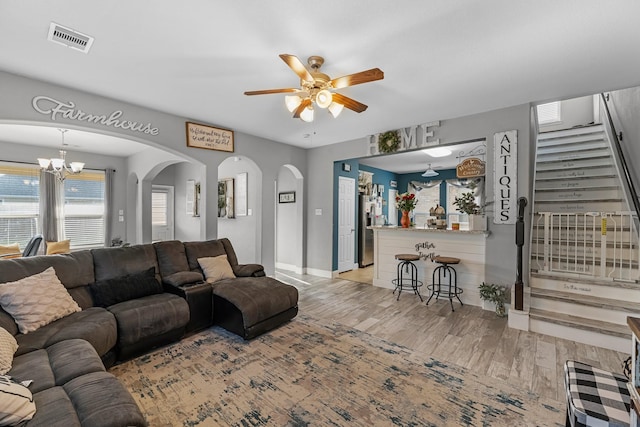 8315 Egret Bay Cir, Baytown, TX 77523 - living area with a ceiling fan, light wood-type flooring, arched walkways, and a chandelier