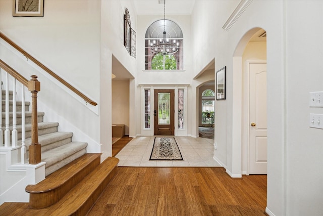 17326 Mesquite Brush Ln, Houston, TX 77095 - foyer entrance with stairway, a chandelier, wood finished floors, arched walkways, and a high ceiling