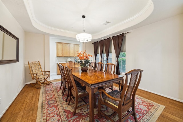 17326 Mesquite Brush Ln, Houston, TX 77095 - dining room with light wood-type flooring, a tray ceiling, crown molding, and a chandelier