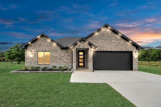 601 Lily St, Waller, TX 77484 - french provincial home featuring brick siding, an attached garage, driveway, and a front yard