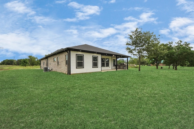 601 Lily St, Waller, TX 77484 - rear view of property with a yard, a patio, and brick siding