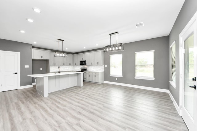 601 Lily St, Waller, TX 77484 - kitchen with stainless steel appliances, light countertops, recessed lighting, backsplash, and light wood-type flooring