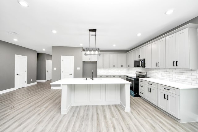 601 Lily St, Waller, TX 77484 - kitchen with stainless steel appliances, a kitchen island with sink, light countertops, and recessed lighting