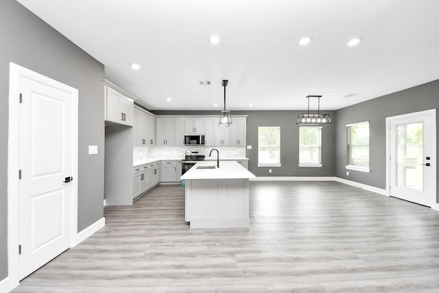 601 Lily St, Waller, TX 77484 - kitchen featuring stainless steel electric range, light countertops, decorative backsplash, pendant lighting, and open floor plan