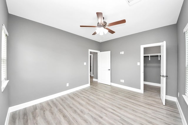 601 Lily St, Waller, TX 77484 - unfurnished bedroom with light wood-style flooring, a walk in closet, a closet, and ceiling fan