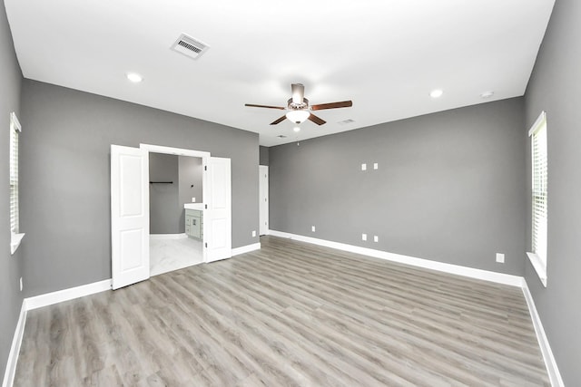 601 Lily St, Waller, TX 77484 - unfurnished bedroom with wood finished floors, ensuite bath, a ceiling fan, and recessed lighting