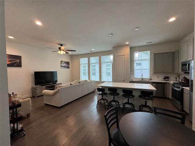 6031 Cypress St, Houston, TX 77074 - kitchen featuring appliances with stainless steel finishes, light countertops, recessed lighting, decorative backsplash, and dark wood finished floors