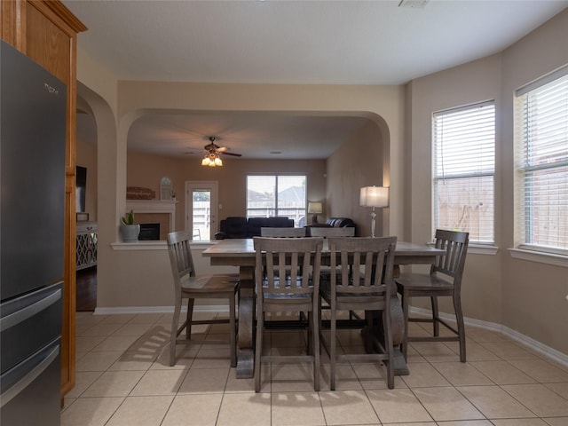 19327 Dickson Park Dr, Spring, TX 77373 - dining room featuring arched walkways, a fireplace, and light tile patterned floors