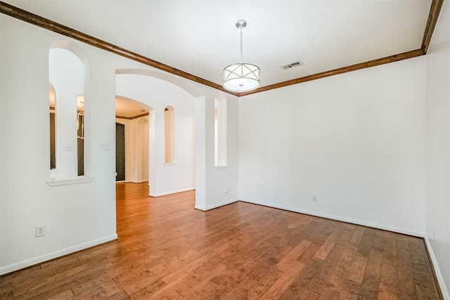 13811 Pepperstone Ln, Houston, TX 77044 - spare room featuring arched walkways, ornamental molding, and wood finished floors