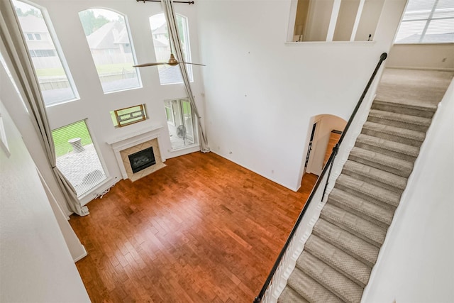 13811 Pepperstone Ln, Houston, TX 77044 - unfurnished living room featuring healthy amount of natural light, stairway, arched walkways, a fireplace, and a towering ceiling