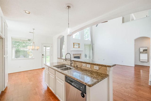 13811 Pepperstone Ln, Houston, TX 77044 - kitchen with stainless steel dishwasher, arched walkways, open floor plan, a fireplace, and stone countertops