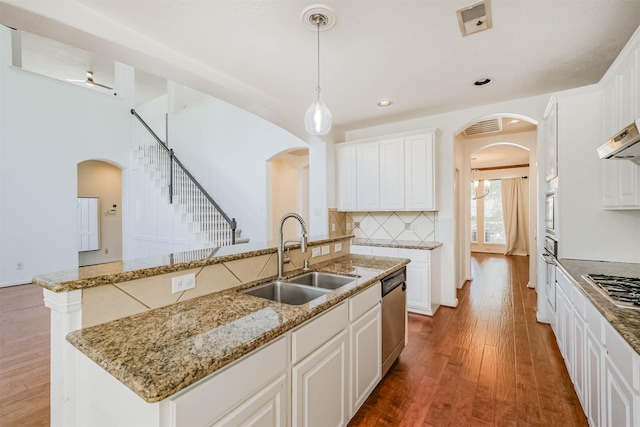 13811 Pepperstone Ln, Houston, TX 77044 - kitchen with arched walkways, stainless steel dishwasher, wood finished floors, and recessed lighting