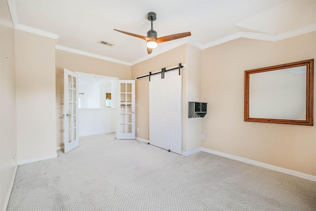 13811 Pepperstone Ln, Houston, TX 77044 - unfurnished bedroom featuring french doors, crown molding, carpet, a barn door, and a ceiling fan