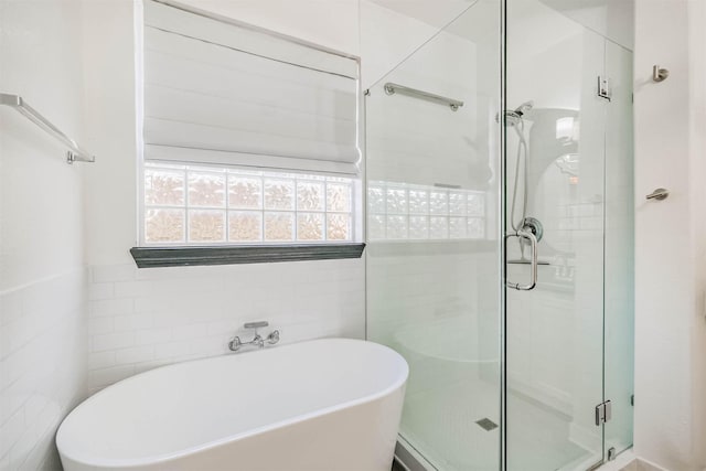 13811 Pepperstone Ln, Houston, TX 77044 - full bathroom featuring a freestanding bath, a shower stall, and tile walls