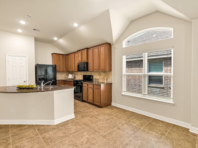 10163 Rose Willow Ln, Brookshire, TX 77423 - kitchen featuring black appliances, lofted ceiling, brown cabinetry, dark stone countertops, and backsplash