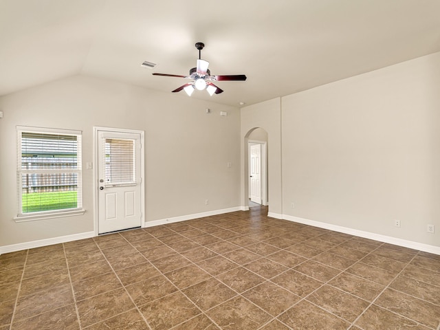 10163 Rose Willow Ln, Brookshire, TX 77423 - spare room with arched walkways, ceiling fan, dark tile patterned floors, and vaulted ceiling