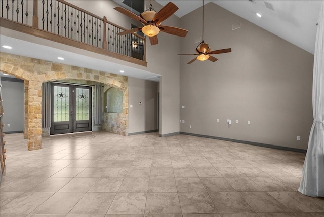 1273 County Road 201a, Angleton, TX 77515 - unfurnished living room with high vaulted ceiling, a ceiling fan, arched walkways, tile patterned floors, and french doors