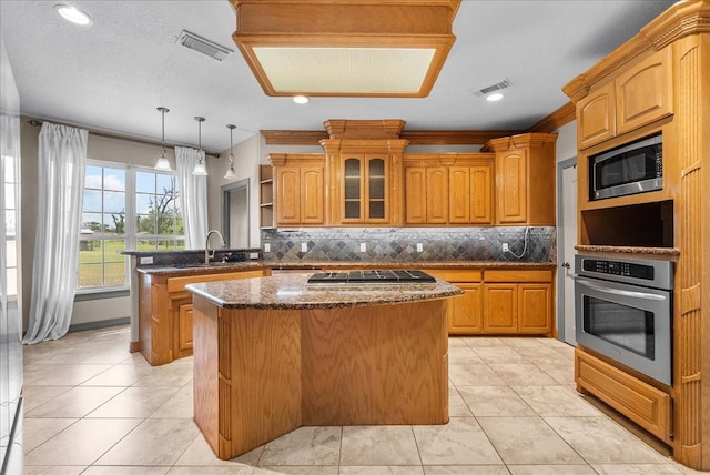 1273 County Road 201a, Angleton, TX 77515 - kitchen with appliances with stainless steel finishes, a center island, open shelves, a peninsula, and decorative backsplash