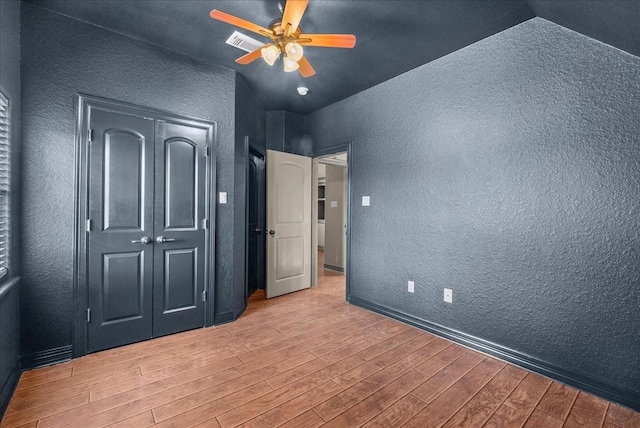 1273 County Road 201a, Angleton, TX 77515 - unfurnished bedroom featuring a textured wall, wood finished floors, vaulted ceiling, and ceiling fan