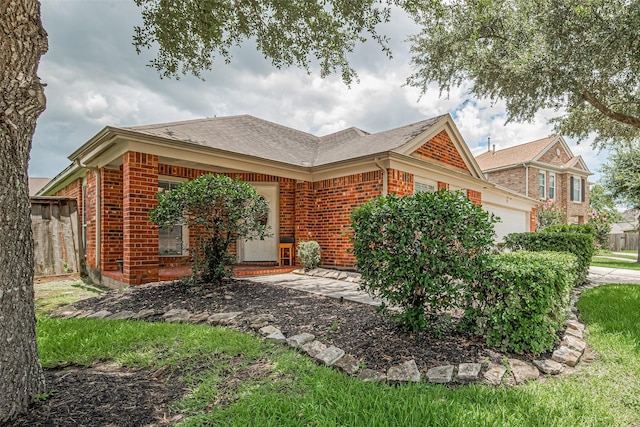 12005 Green Falls Dr, Pearland, TX 77584 - view of home's exterior with brick siding, a garage, and a shingled roof