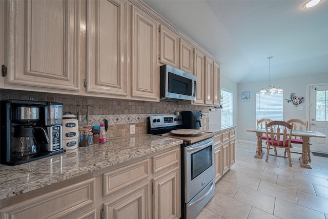 12005 Green Falls Dr, Pearland, TX 77584 - kitchen featuring stainless steel appliances, tasteful backsplash, a chandelier, cream cabinetry, and light tile patterned floors