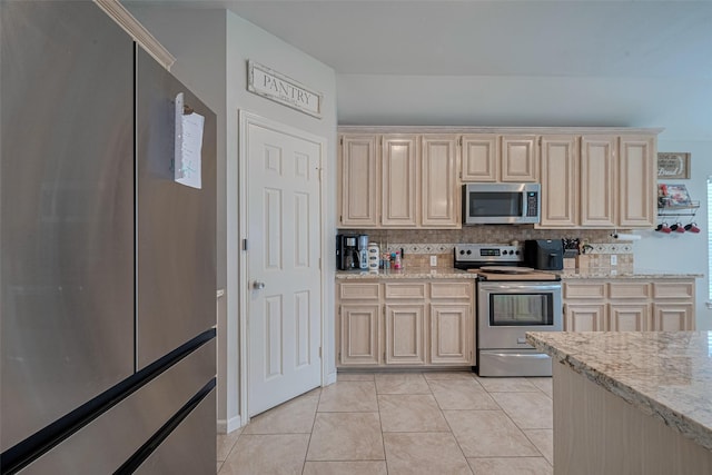 12005 Green Falls Dr, Pearland, TX 77584 - kitchen featuring stainless steel appliances, backsplash, light stone countertops, and light tile patterned floors