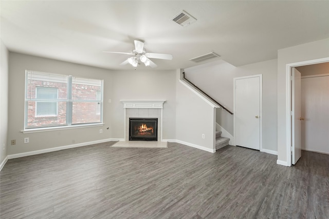 1019 Sawgrass Ridge Ln, Houston, TX 77073 - unfurnished living room featuring wood finished floors, a tile fireplace, ceiling fan, and stairs