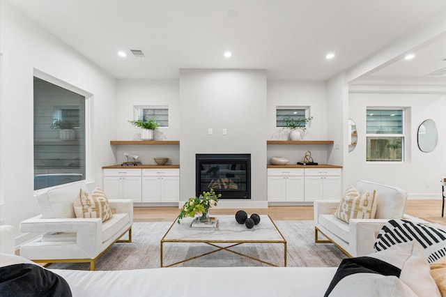4403 Feagan, Houston, TX 77007 - living area with light wood-type flooring, recessed lighting, and a glass covered fireplace