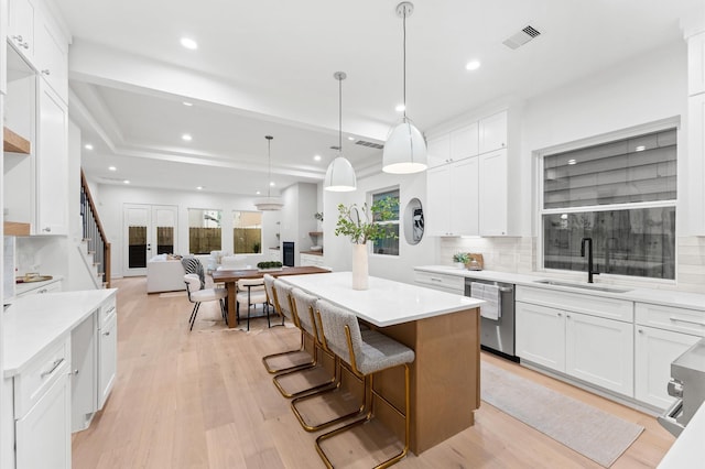 4403 Feagan, Houston, TX 77007 - kitchen with dishwasher, a center island, decorative backsplash, white cabinets, and light countertops