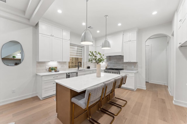 4403 Feagan, Houston, TX 77007 - kitchen featuring backsplash, arched walkways, light wood finished floors, light countertops, and recessed lighting