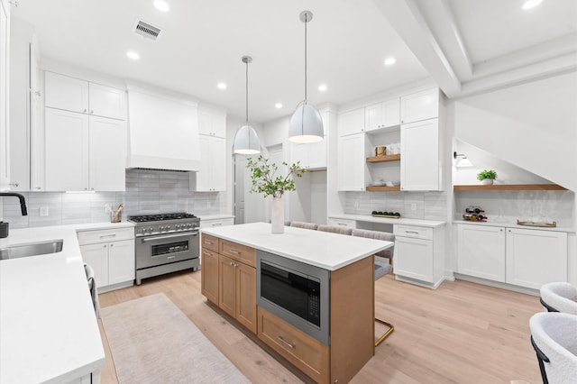4403 Feagan, Houston, TX 77007 - kitchen featuring stainless steel appliances, open shelves, decorative backsplash, premium range hood, and light wood-style floors
