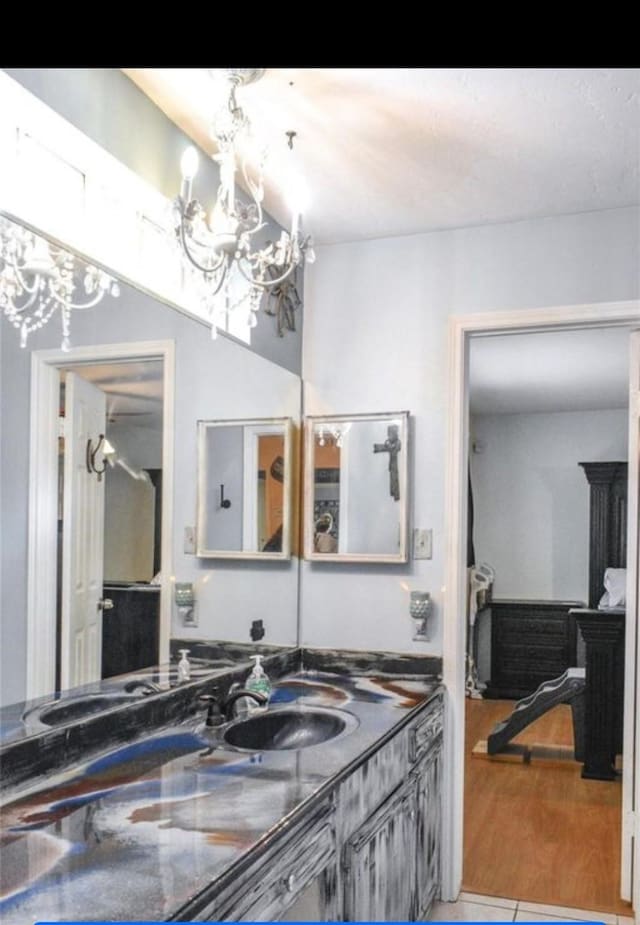 324 E Hunting Tower Run, Montgomery, TX 77316 - bathroom with a chandelier, vanity, and wood finished floors