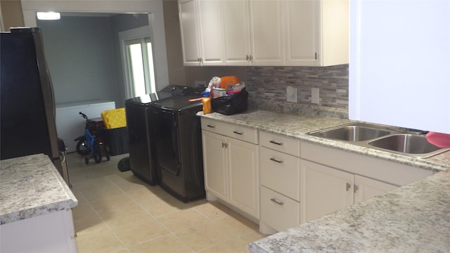 232 Birch St, Lake Jackson, TX 77566 - kitchen with washing machine and clothes dryer, freestanding refrigerator, light countertops, and white cabinetry
