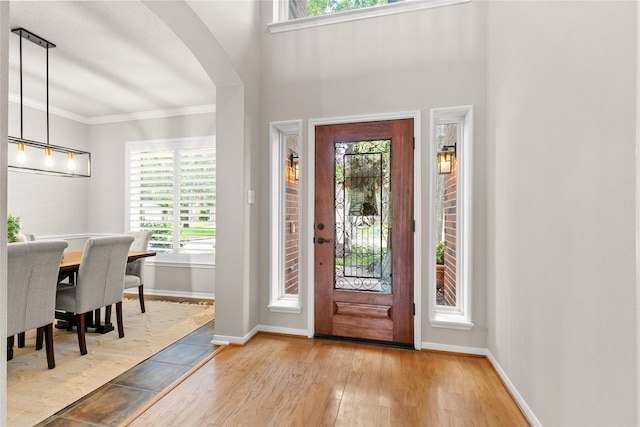 14427 Wickhurst Pl, Cypress, TX 77429 - foyer with light wood-type flooring, arched walkways, and crown molding