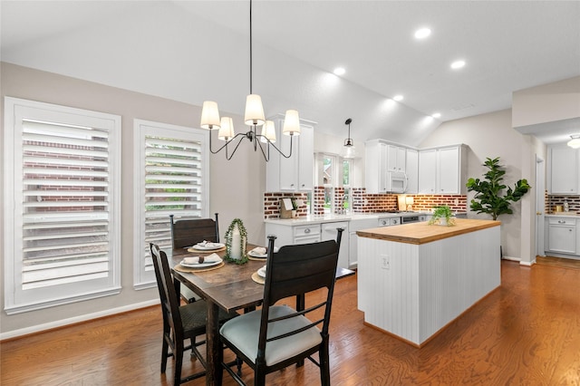 14427 Wickhurst Pl, Cypress, TX 77429 - kitchen featuring wooden counters, decorative backsplash, vaulted ceiling, wood finished floors, and white cabinetry