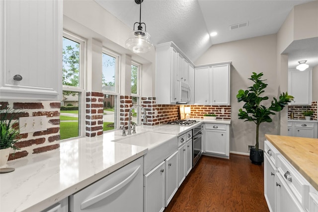 14427 Wickhurst Pl, Cypress, TX 77429 - kitchen with stainless steel appliances, decorative backsplash, dark wood finished floors, wooden counters, and white cabinetry