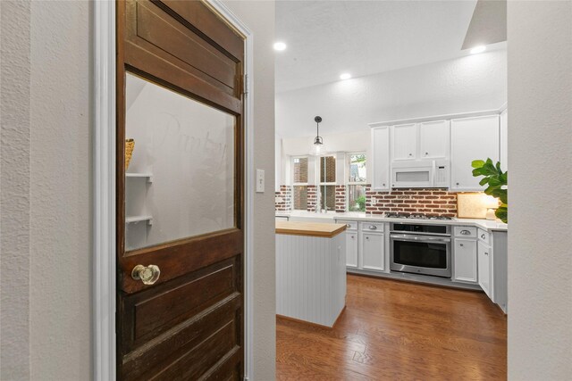 14427 Wickhurst Pl, Cypress, TX 77429 - kitchen with appliances with stainless steel finishes, white cabinetry, dark wood-style floors, butcher block counters, and tasteful backsplash